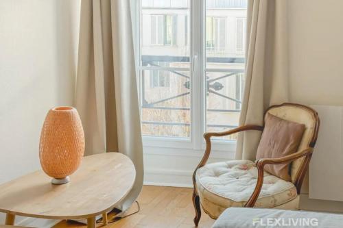 une pièce avec une chaise, une table et une fenêtre dans l'établissement Flexliving - T2 - Guy de la Brosse, à Paris