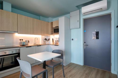 a kitchen with a table and chairs and a door at Luxury Studio Apartments in Cork City Centre in Cork
