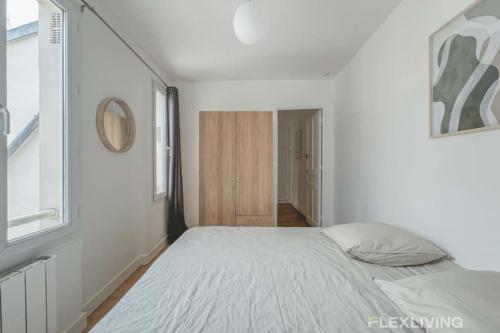 une chambre blanche avec un lit et une fenêtre dans l'établissement Flexliving - room - Saint Martin, à Paris