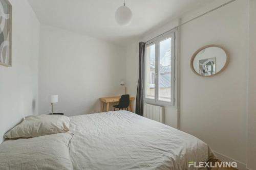 une chambre avec un lit, un miroir et une fenêtre dans l'établissement Flexliving - room - Saint Martin, à Paris