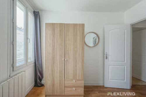 une armoire en bois dans une chambre avec fenêtre dans l'établissement Flexliving - room - Saint Martin, à Paris