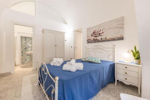 a bedroom with a blue bed with towels on it at Appartamento Misya in Felline