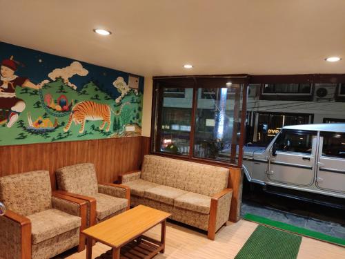 a living room with a couch and chairs and a painting at KG Tusheta - 200 mtrs from MG Marg in Gangtok