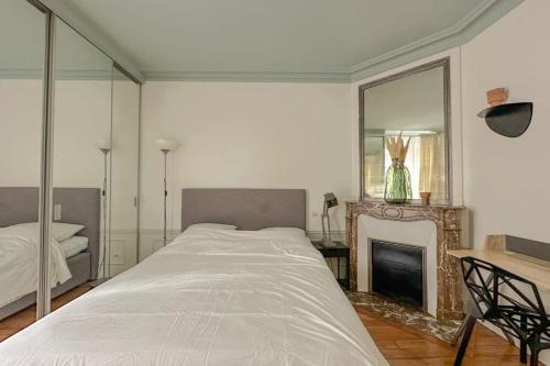 - une chambre avec un lit, une cheminée et un miroir dans l'établissement Flexliving - whole flat - Bachaumont, à Paris