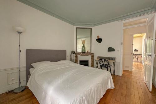 une chambre avec un lit blanc et une table dans l'établissement Flexliving - whole flat - Bachaumont, à Paris