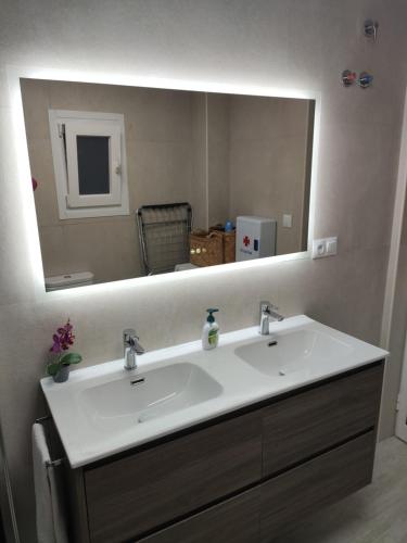 a bathroom with a sink and a large mirror at Casita La Playa in Málaga