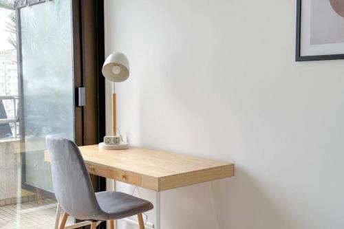 - un bureau dans une chambre avec une chaise et une lampe dans l'établissement Flexliving - whole apartment - Hillairet, à Paris