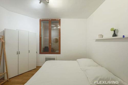 une chambre blanche avec un lit et des armoires blanches dans l'établissement Flexliving - whole flat - Banquier, à Paris