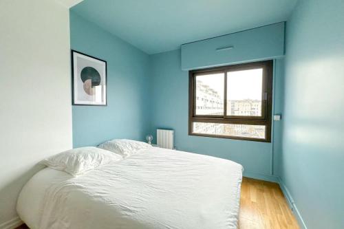 une chambre bleue avec un lit et une fenêtre dans l'établissement Flexliving - whole apartment - Hillairet, à Paris