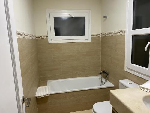 a bathroom with a tub and a tv on the wall at Villa Loma Beach in Chiclana de la Frontera