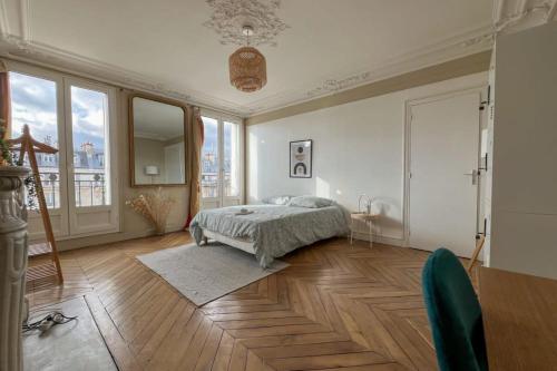 - une chambre avec un lit, du parquet et des fenêtres dans l'établissement Flexliving - whole flat - Voltaire, à Paris