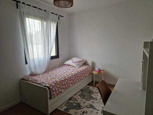 une petite chambre avec un lit et une fenêtre dans l'établissement Maison climatisée avec piscine, à Sallèles-dʼAude