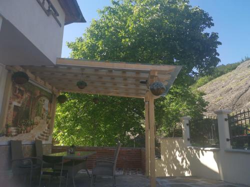 a wooden pergola with a table and chairs at Къща Томови in Devin