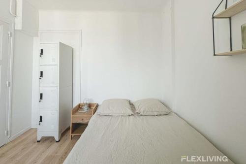 une chambre blanche avec un lit et une commode dans l'établissement Flexliving - whole apartment - Houel, à Paris