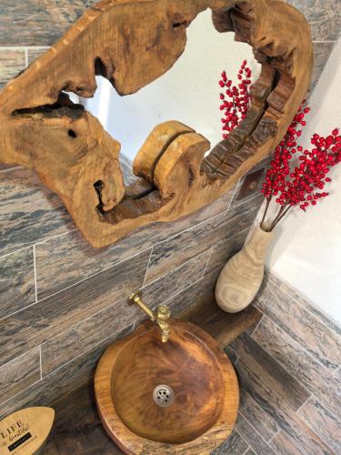 a bathroom with a wooden toilet and a mirror at Къща Томови in Devin