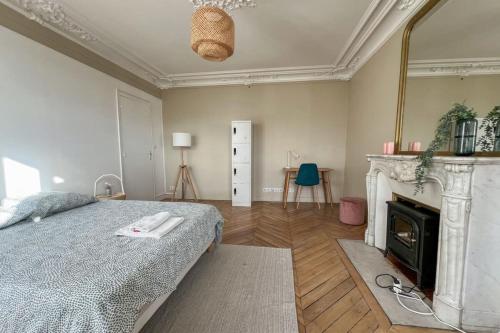 - une chambre avec un lit, une cheminée et un miroir dans l'établissement Flexliving - whole flat - Voltaire, à Paris
