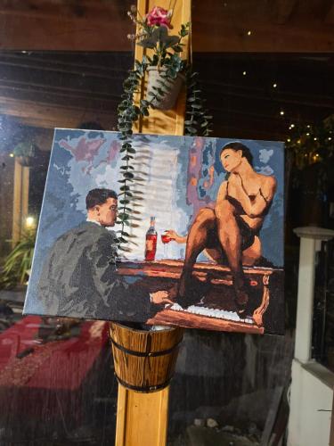 a painting of a man and a woman sitting on a bar at Къща Томови in Devin
