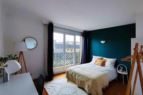 une chambre avec un lit et une grande fenêtre dans l'établissement Flexliving - whole flat - Villon, à Paris