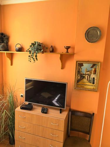 a flat screen tv sitting on top of a wooden dresser at Къща Томови in Devin