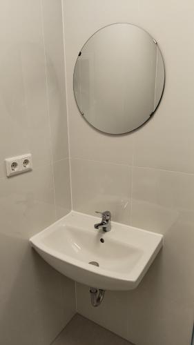 a white sink in a bathroom with a mirror at Apartment for 2 guests in Geesthacht