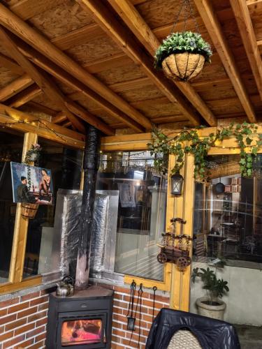 a wood stove in a restaurant with a ceiling at Къща Томови in Devin