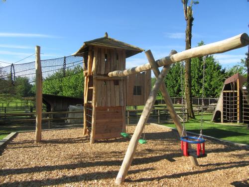 a playground with a wooden swing set in a park at Wirtshaus Rütihof in Gränichen