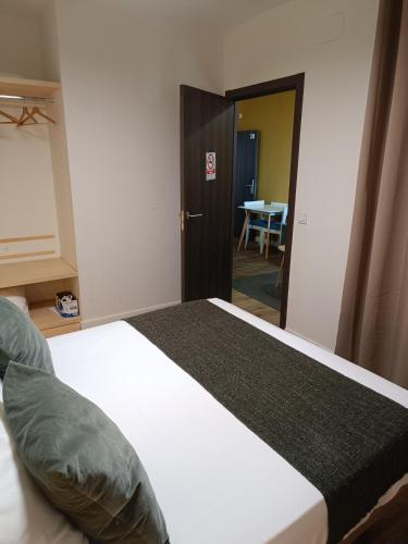 a bedroom with a bed and a table in a room at Apartamentos AL-QAZERES LUXURY La Concepción in Cáceres