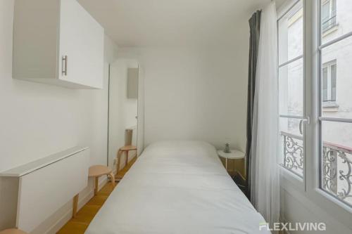 un lit dans une chambre avec une fenêtre dans l'établissement Flexliving - Studio - Étienne Marcel, à Paris