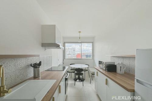 une cuisine avec un comptoir et une table à l'intérieur dans l'établissement Flexliving - whole apartment - Mouchez, à Paris