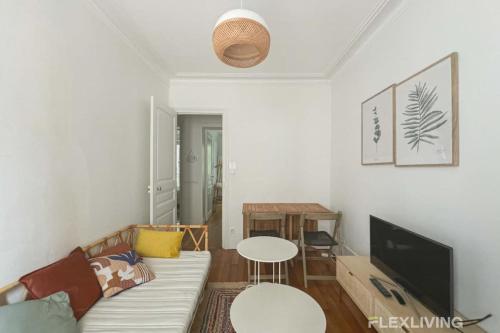 un salon avec un canapé et une table dans l'établissement Flexliving - whole apartment - Caulaincourt, à Paris