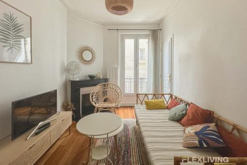un salon avec un canapé et une table dans l'établissement Flexliving - whole apartment - Caulaincourt, à Paris