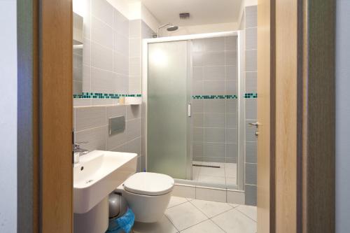 y baño con aseo, lavabo y ducha. en Hostel Orange, en Praga