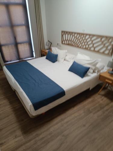 a large bed with blue pillows in a room at Apartamentos AL-QAZERES LUXURY La Concepción in Cáceres
