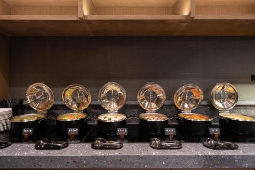 a bunch of pots and pans on a stove with food at Atour Hotel Shijiazhuang Chang'an Guanghua Road in Shijiazhuang