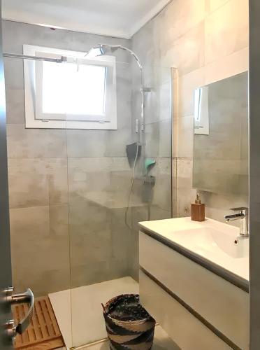 une salle de bain avec une douche en verre et un lavabo dans l'établissement Appartement à Ajaccio avec vue sur la mer, à Ajaccio