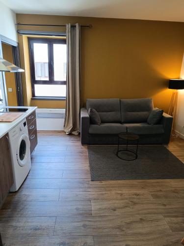 a living room with a couch and a washing machine at Apartamentos AL-QAZERES LUXURY La Concepción in Cáceres