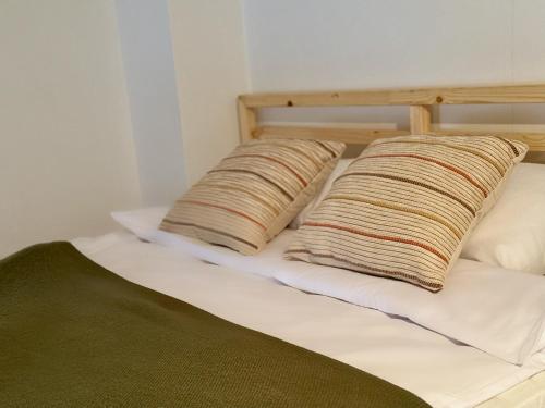 a bed with two pillows on top of it at Cozy Cottage in Oświęcim