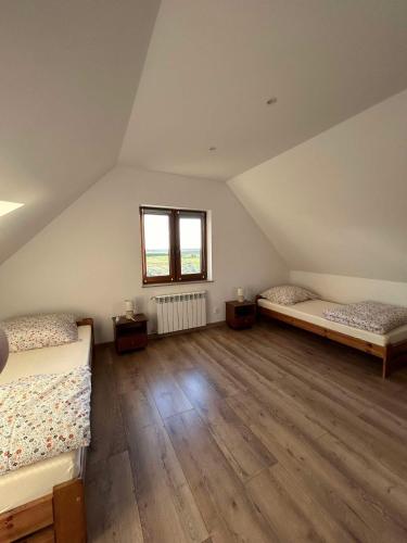 a attic room with two beds and a window at Domek Sosenka in Czarnówka