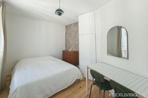 - une chambre avec un lit et un bureau avec un miroir dans l'établissement Flexliving - Studio - Durantin, à Paris