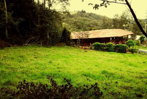 a grassy field with a building in the background at Monzaque- paraíso de bachué in El Barrial