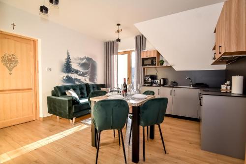a kitchen and living room with a table and chairs at Apartamenty u Kurosa Jacuzzi & Sauna Ski Suche in Poronin