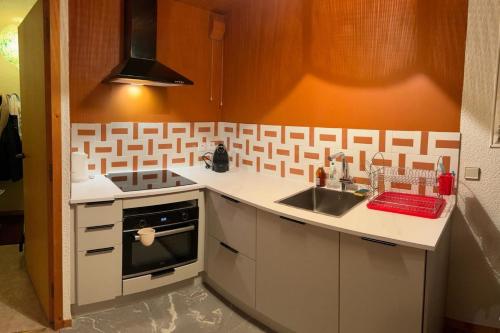 une petite cuisine avec un évier et une cuisinière dans l'établissement Family T3 near the slopes Méribel, à Méribel