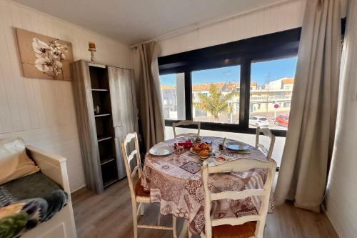une table de salle à manger avec vue sur un balcon dans l'établissement L'Escapade Salée - A 100 mètres de la plage et en plein coeur de ville, au Grau-du-Roi