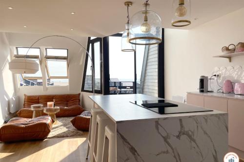 - une cuisine avec un îlot dans une chambre avec un canapé dans l'établissement La Vie en Rose - Terrasse vue Mer - Plage - Marina, à Deauville