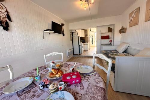 Cette chambre comprend une table avec des assiettes de nourriture. dans l'établissement L'Escapade Salée - A 100 mètres de la plage et en plein coeur de ville, au Grau-du-Roi