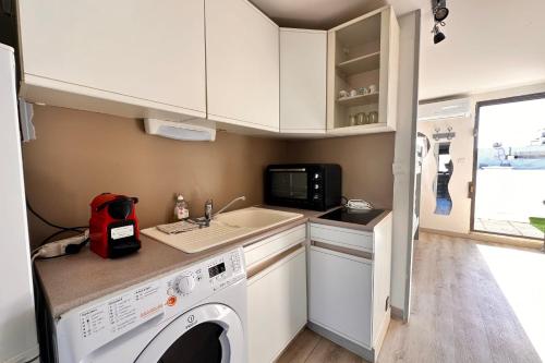 - une cuisine avec un lave-linge dans une caravane dans l'établissement L'Escapade Salée - A 100 mètres de la plage et en plein coeur de ville, au Grau-du-Roi