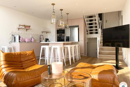 un salon avec un canapé et une cuisine dans l'établissement La Vie en Rose - Terrasse vue Mer - Plage - Marina, à Deauville