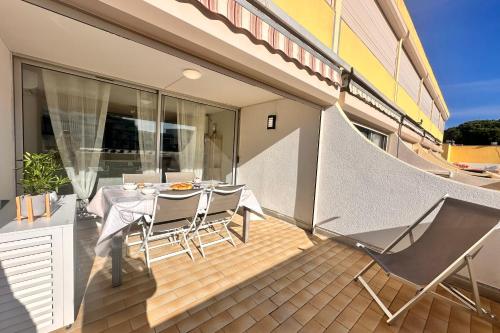 un patio avec une table et des chaises sur un balcon dans l'établissement Le Catamaran - Studio proche de la mer avec terrasse, au Grau-du-Roi