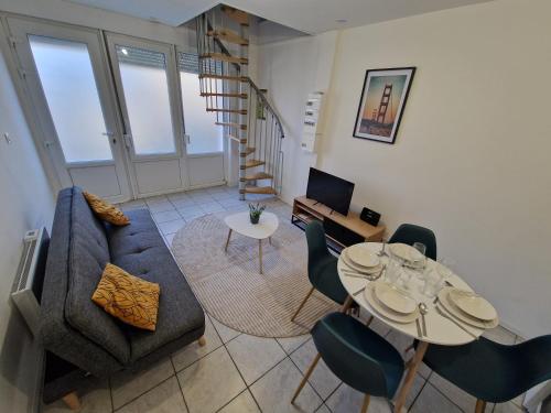 a living room with a couch and a table and chairs at Duplex tout équipé in Marpent