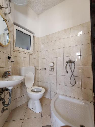 Un baño con inodoro, lavabo y bañera. en Altura Rooms & Apartments, en Neum